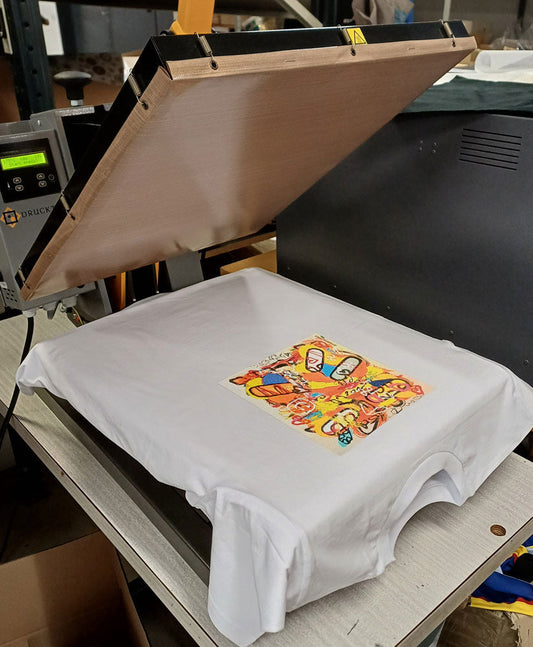 Taidepaitojen kuvat prässätään kiinni kankaaseen.